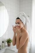 Chica aplicando parche nasal tras la ducha